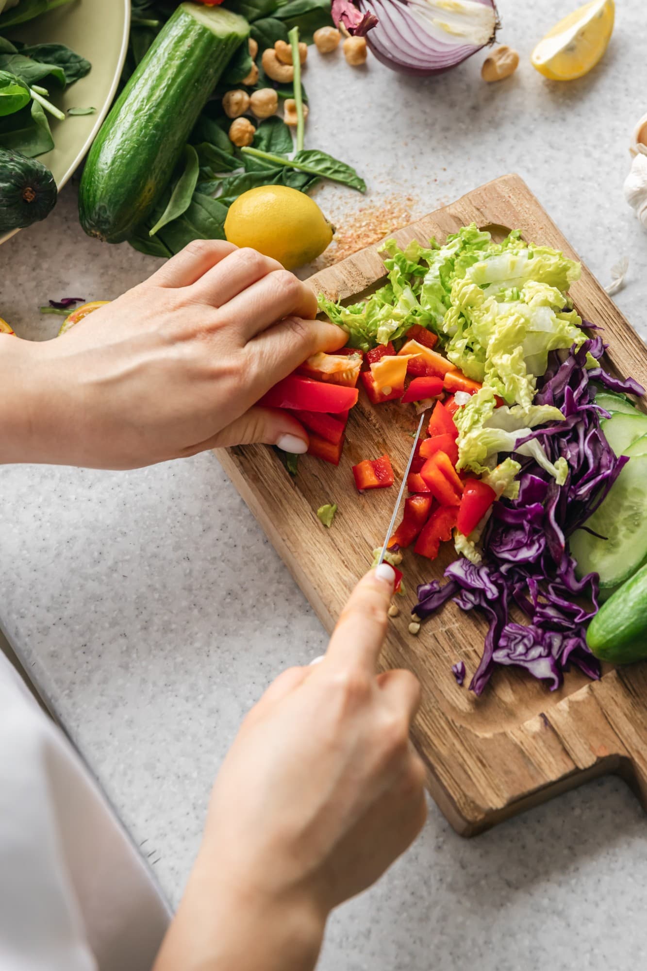Manos cortando verduras de colores sobre una tabla de madera